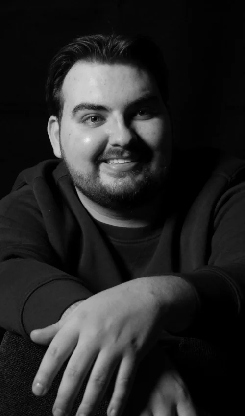 Zwart-wit portret van Robin van Vliet, director en DoP, met een open en toegankelijke uitstraling